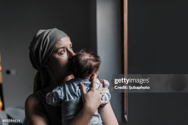 foto von nachdenklichen frau schaut aus dem fenster ihres sohnes mit gedrückter - baby depression stock-fotos und bilder