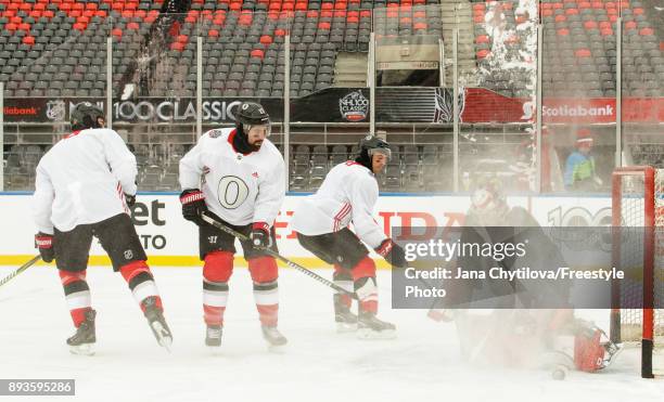 Craig Anderson of the Ottawa Senators makes a pad save against teammates Nate Thompson and Gabriel Dumont during practice at Lansdowne Park on...