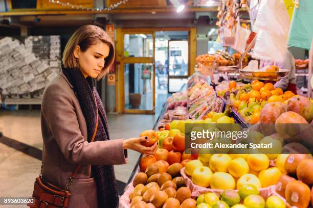 young woman buying fruits at the farmer's market - barcelona shopping stock pictures, royalty-free photos & images