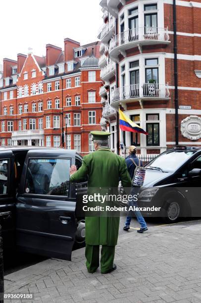 Harrods department store doorman assists a shopper into a taxi in front of the luxury department store in London, England.