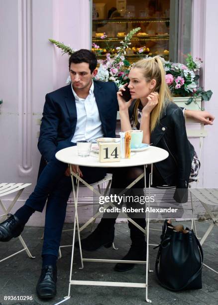 Stylish couple stop for a snack at a coffee and dessert shop in the Belgravia district of London, England.