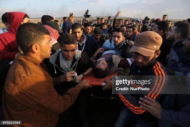 Palestinian protesters carry away an injured man during clashes with with Israeli security forces near the border fence with Israel, east of Gaza...