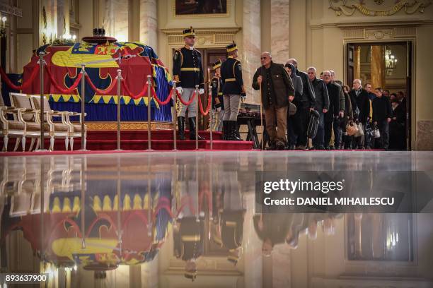 People stay in line to pay their respects to the late King Michael I of Romania inside the former Royal Palace that houses the National Arts Museum,...