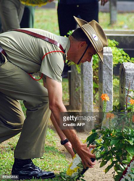 Asia-WWII-history-cemeteries BY ROMEN BOSE In a picture dated June 11, 2009 an unidentified Australian soldier places flowers on tombstones of the...