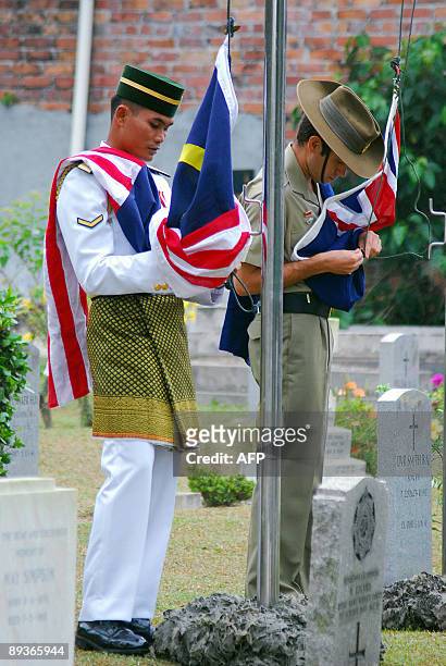 Asia-WWII-history-cemeteries BY ROMEN BOSE A picture dated June 11, 2009 shows Malaysian and Australian soldiers raising flags of their respective...