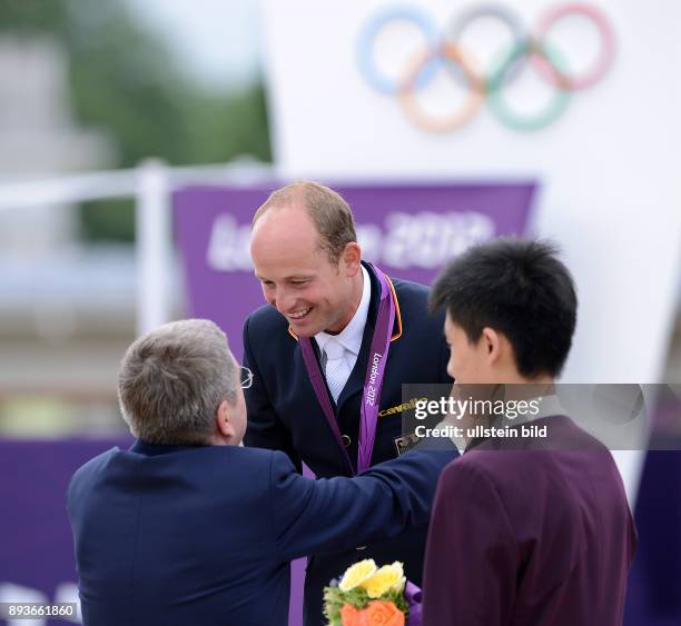 Olympia 2012 London Reiten Vielseitigkeit Thomas Bach ueberreicht Michael Jung die Goldmedaille bei der Siegerehrung im Einzelwertung