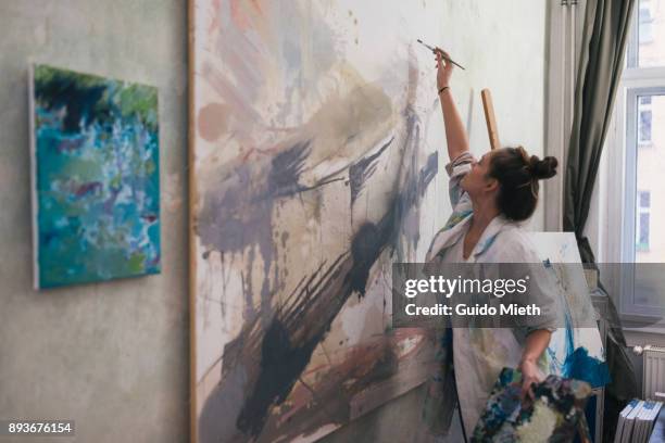 woman painting a big work in studio. - 芸術家 ストックフォトと画像