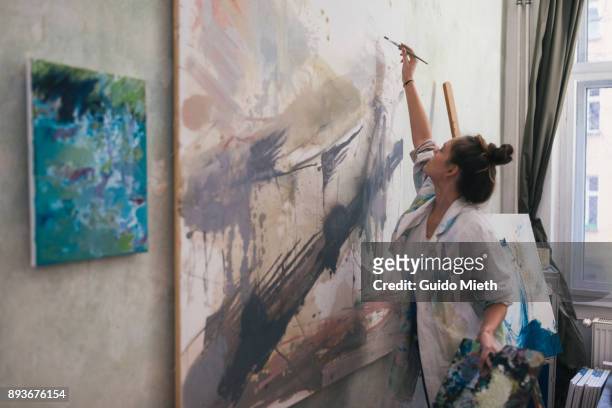 woman painting a big work in studio. - arte e artesanato objeto manufaturado - fotografias e filmes do acervo
