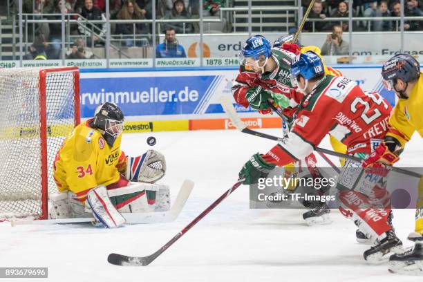 Goalkeeper Dan Bakala of Duesseldorfer EG, Thomas Holzmann of Augsburger Panther and T.J. Trevelyan of Augsburger Panther battle for the ball during...