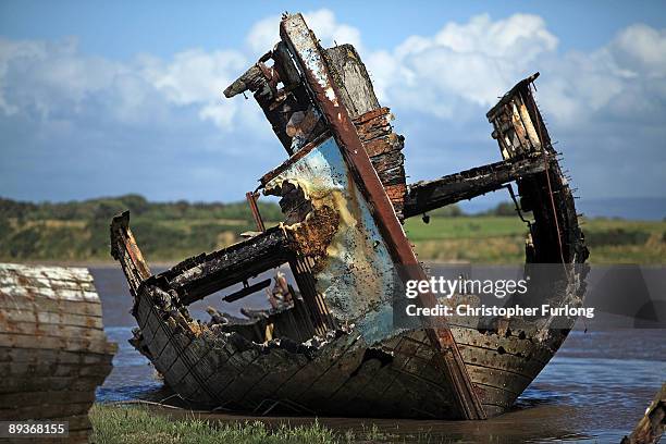 The rotting hulks of old boats decay in the sands of Fleetwood Marshes on July 27, 2009 in Fleetwood, England. Seven boats have been rusting and...