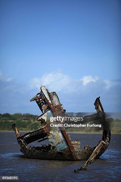 The rotting hulks of old boats decay in the sands of Fleetwood Marshes on July 27, 2009 in Fleetwood, England. Seven boats have been rusting and...