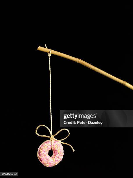 doughnut on stick on black background. - want stock pictures, royalty-free photos & images