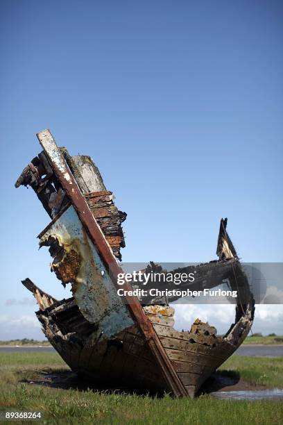 The rotting hulks of old boats decay in the sands of Fleetwood Marshes on July 27, 2009 in Fleetwood, England. Seven boats have been rusting and...