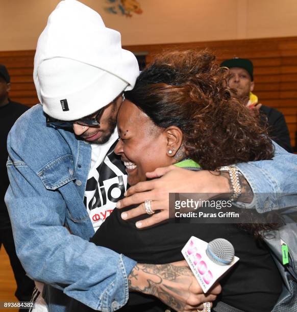 Singer Chris Brown surprises school teacher Tracie Reeves with a donation of $50,000 to her school at V-103 Atlanta Winterfest pop-up at Columbia...