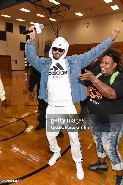 Singer Chris Brown surprises school teacher Tracie Reeves with a donation of $50,000 to her school at V-103 Atlanta Winterfest pop-up at Columbia...