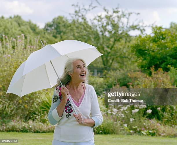 mature woman with parasol, smiling - northampton england stock pictures, royalty-free photos & images