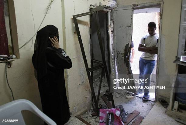 Palestinians react as they inspect damages in their family house following a raid by Israeli forces overnight in the Balata refugee camp, in the West...