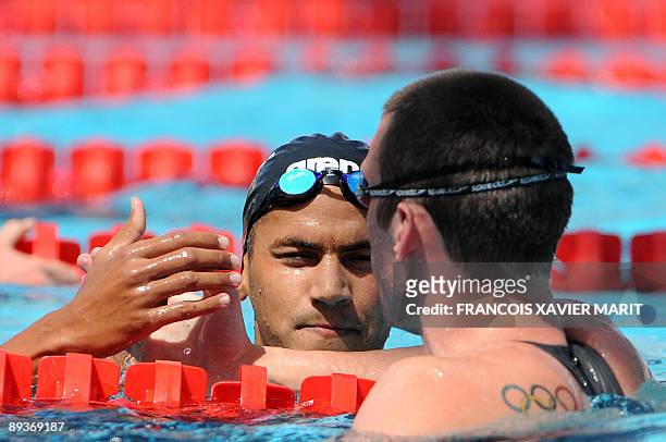 Tunisia's Oussama Mellouli and Canada's Ryan Cochrane congratulate each other after the men's 800m freestyle qualifications on July 28, 2009 at the...