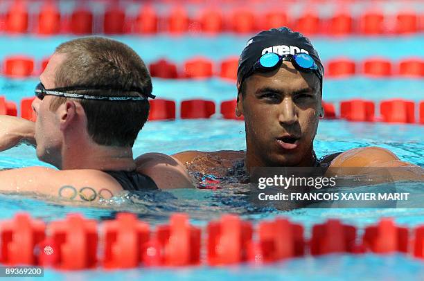 Tunisia's Oussama Mellouli and Canada's Ryan Cochrane react after the men's 800m freestyle qualifications on July 28, 2009 at the FINA World Swimming...