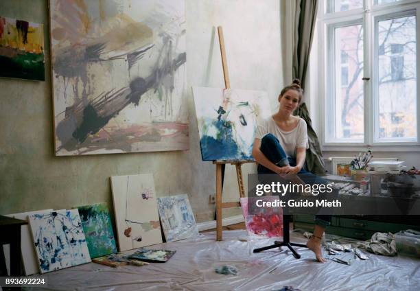 portrait of a female artist with her works. - artist painter stock-fotos und bilder