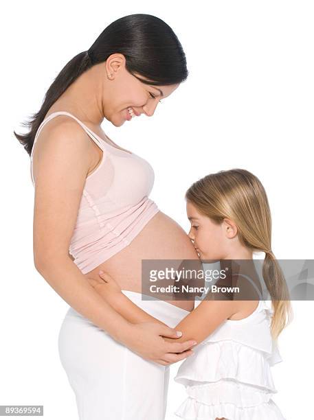 ethnic pregnant woman with little girl. - belly kissing stock-fotos und bilder