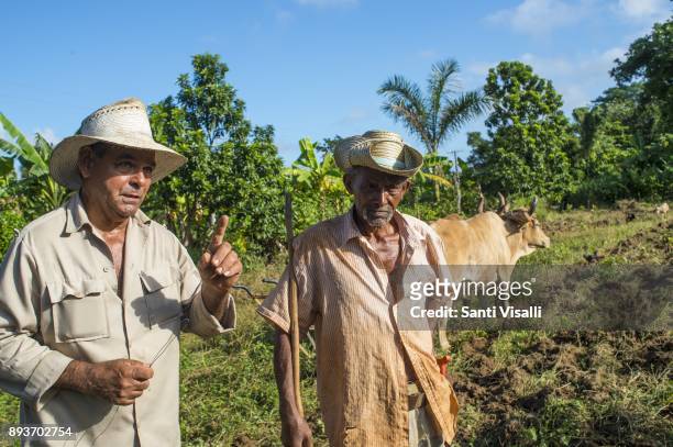 Farmer Juanito left and Nino posing for a photo on November 9, 2017 in Vinales, Cuba.