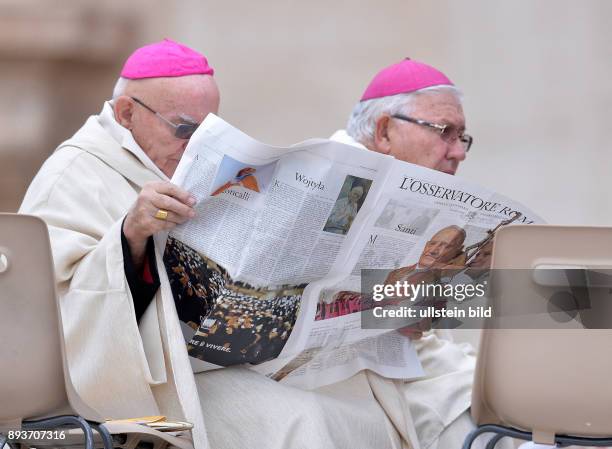 Rom, Vatikan Heiligsprechung Papst Johannes Paul II und Papst Johannes XXIII Zwei Bischoefe lesen vor der Messe die aktuelle Ausgabe des Osservatore...