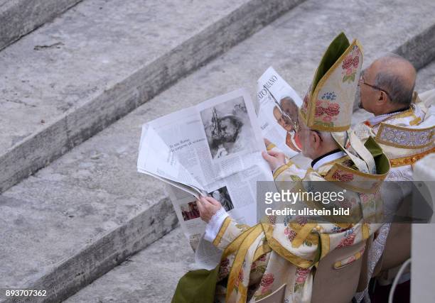 Rom, Vatikan Heiligsprechung Papst Johannes Paul II und Papst Johannes XXIII Zwei Bischoefe lesen vor der Messe die aktuelle Ausgabe des Osservatore...