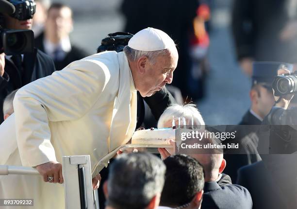 Rom, Vatikan Papst Franziskus I. Pustet an seinem 78. Geburtstag waehrend der woechentlichen Generalaudienz auf dem Petersplatz Kerzen auf einer...