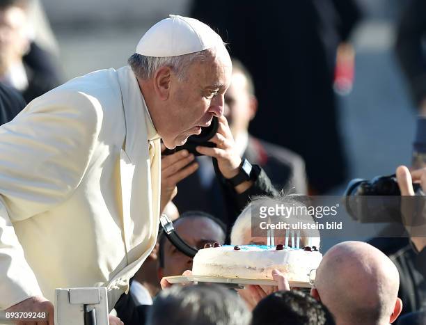 Rom, Vatikan Papst Franziskus I. Pustet an seinem 78. Geburtstag waehrend der woechentlichen Generalaudienz auf dem Petersplatz Kerzen auf einer...