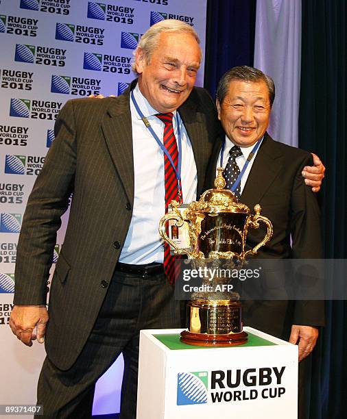 England's Martyn Thomas and Japan's Noboru Mashimo celebrate after the 26-man council of the International Rugby Board decided the venues for the...