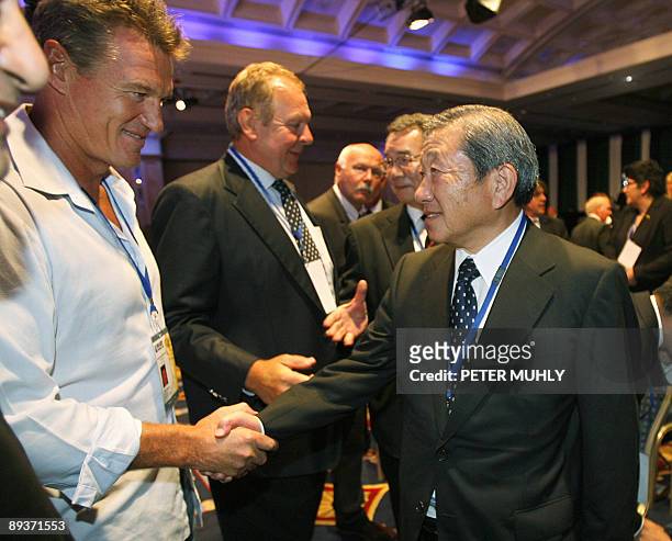Japan's rugby-union world cup bid representative Noboru Mashimo is congraulated by Japan's rugby-union coach John Kirwan after a 26-man council of...