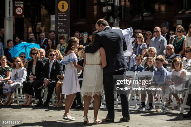 Katrina Dawsons's daughter Chloe hugs her father Paul Smith during the unveiling of a permanent memorial honouring the lives of Tori Johnson and...