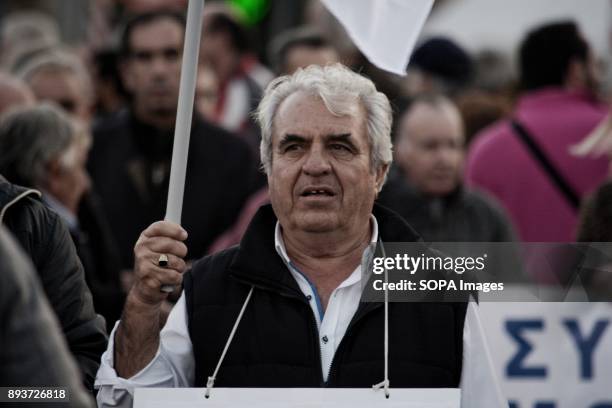 Pensioner hold flag during the protest of pensioners at Syntagma Square. They are protesting to the government of pension cuts and austerity policies.