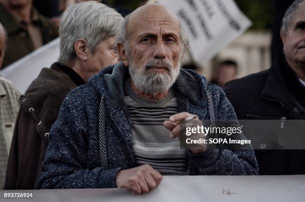 Pensioner holds banner during the protest of pensioners at Syntagma Square. They are protesting to the government of pension cuts and austerity...