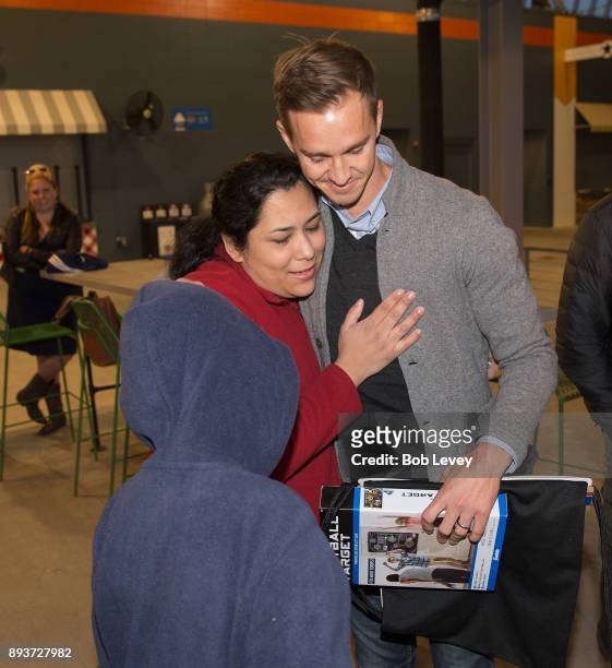 Stu Holden hugs Diane Morales during the Kick in for Houston participants and Leesa Sleep surprise familes affected by Hurricane Harvey with gifts at...