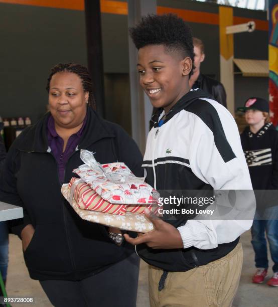 Families receive their gift during the Kick in for Houston participants and Leesa Sleep surprise familes affected by Hurricane Harvey with gifts at...