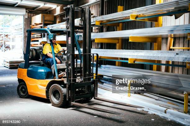 藍領工人在倉庫中駕駛叉車 - forklift 個照片及圖片檔