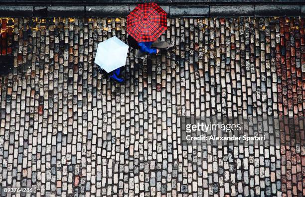 high angle view of cobblestone street and umbrellas - edinburgh scotland stockfoto's en -beelden