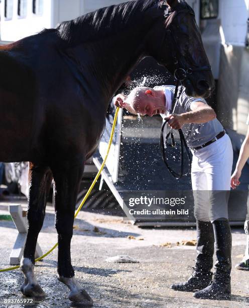 Reiten Reitenturnier Pulvermuehle Dusslingen 2016 Springpruefung Kl. M Abkuehlung fuer Pferd und Reiter bei 30 C Grad Hitze; Frank Angst duscht nach...