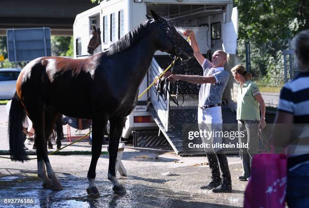 Reiten Reitenturnier Pulvermuehle Dusslingen 2016 Springpruefung Kl. M Abkuehlung fuer die Pferd bei 30 C Grad Hitze; Frank Angst duscht Pferd...