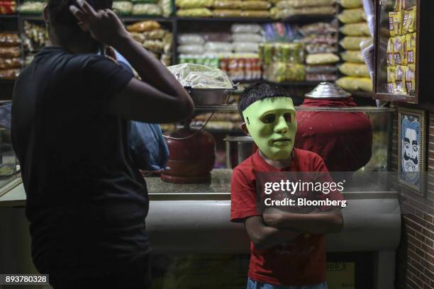 Child wears a green costume mask at a store in Mumbai, India, on Friday, Dec. 15, 2017. India's inflation surged past the central bank's target,...