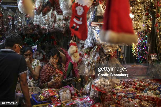 Customers look at festive Christmas decorations at a stall in Mumbai, India, on Friday, Dec. 15, 2017. India's inflation surged past the central...