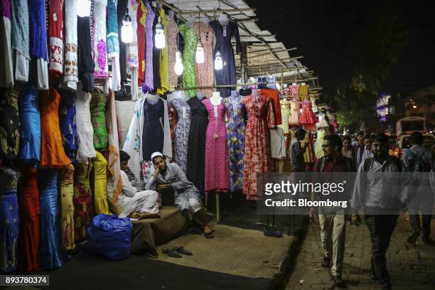 Vendors wait for customers at a clothing stall in Mumbai, India, on Friday, Dec. 15, 2017. India's inflation surged past the central bank's target,...