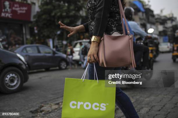 Shopper holds a Crocs Inc. Branded shopping bag in Mumbai, India, on Friday, Dec. 15, 2017. India's inflation surged past the central bank's target,...