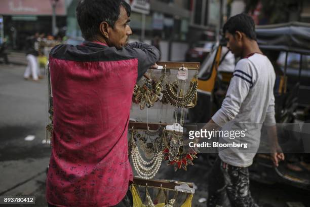 Roadside vendor selling necklaces waits for customers in Mumbai, India, on Friday, Dec. 15, 2017. India's inflation surged past the central bank's...