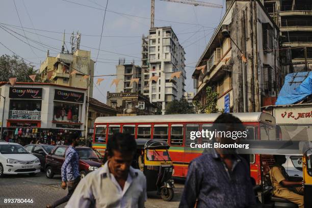 Pedestrians and traffic move past buildings in Mumbai, India, on Friday, Dec. 15, 2017. India's inflation surged past the central bank's target,...