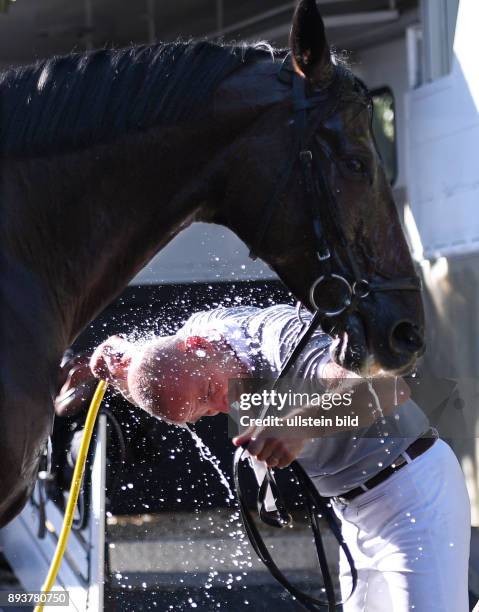 Reiten Reitenturnier Pulvermuehle Dusslingen 2016 Springpruefung Kl. M Abkuehlung fuer Pferd und Reiter bei 30 C Grad Hitze; Frank Angst duscht nach...