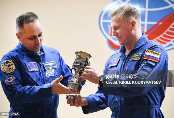 Anton Shkaplerov of Roscosmos and his back up crew member Sergei Prokopiev pose with a replica of the Gagarin Cup - the trophy of the Russia's...