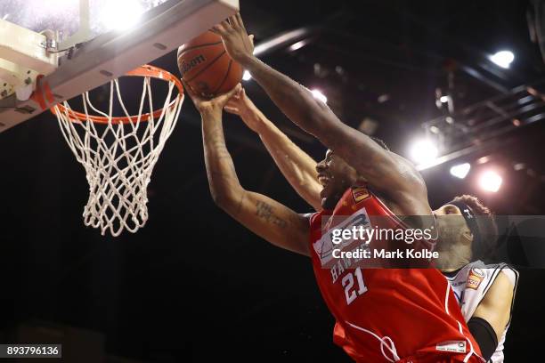Delvon Johnson of the Hawks drives to the basket under pressure from Josh Boone of Melbourne United during the round 10 NBL match between the...